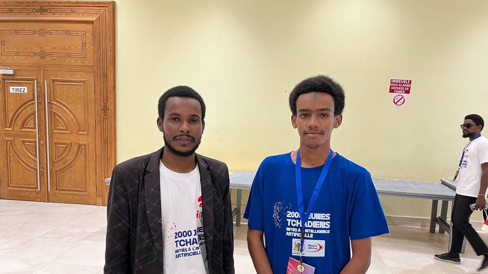 Amdjad Aboubakar, in blue and wearing a participant badge, with a fellow participant at the AI training for 2,000 young Chadians